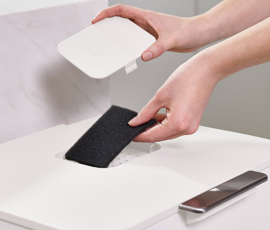 Une femme insère un filtre dans une poubelle de tri sélectif Joseph Joseph.