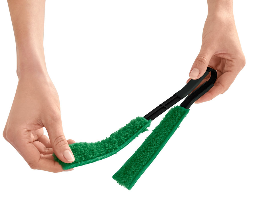 Des mains tiennent une brosse à végétaux.