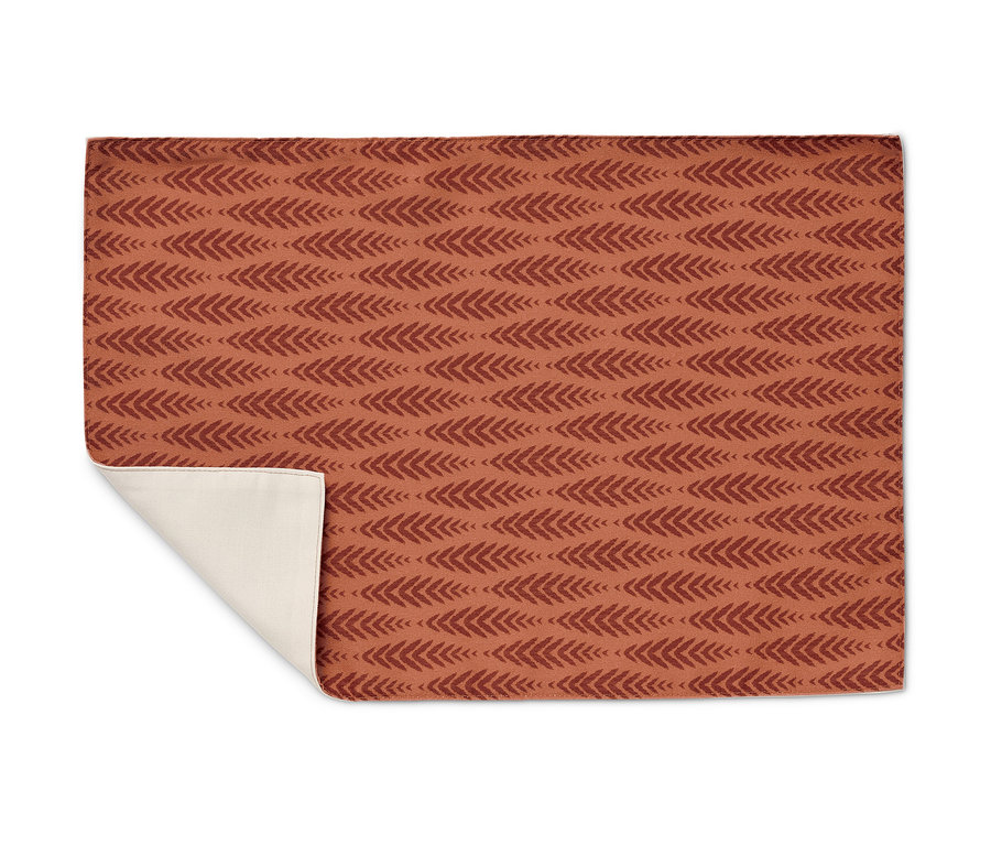 Vue détaillée d'un set de table réversible à motif à chevrons terracotta.