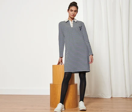Femme posant en robe molletonnée à rayures avec col polo.