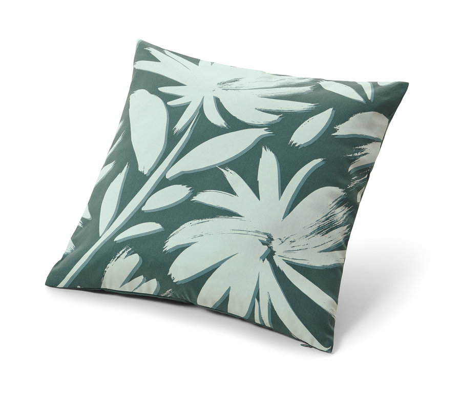 Housse de coussin décorative avec motif floral sur fond vert foncé.