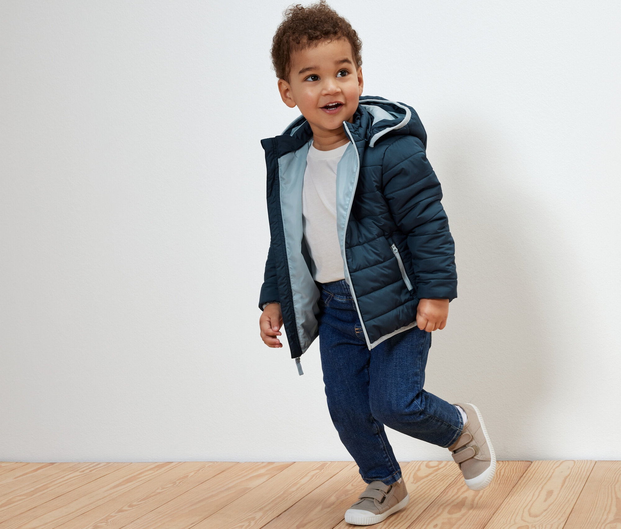 Garçon portant une veste matelassée bleu marine pour enfant.