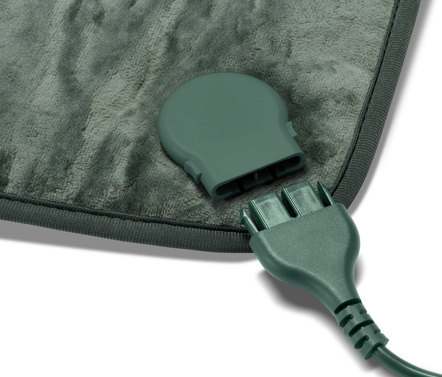 Gros plan sur un petit coussin chauffant et son câble débranché.