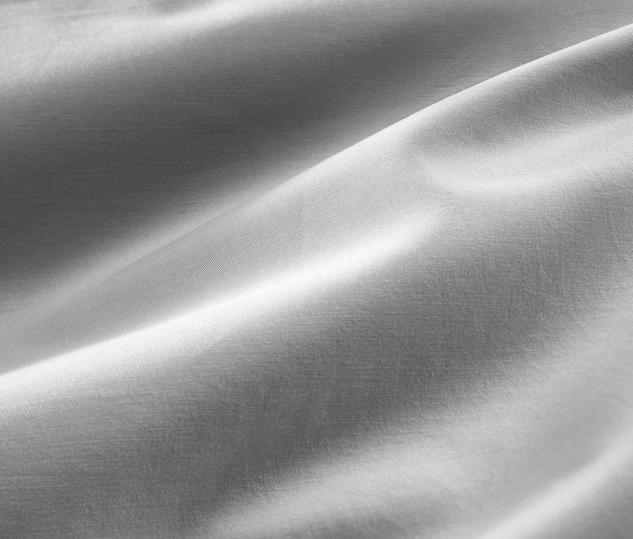 Gros plan d'une parure de lit en satin de coton gris de taille standard et grande taille.