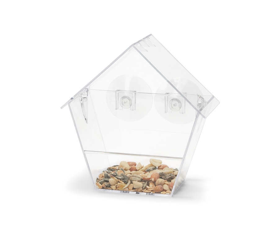 Une mangeoire à oiseaux transparente remplie de graines.