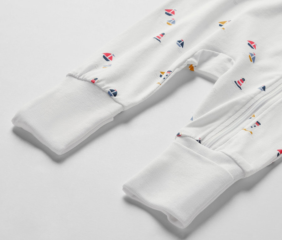 Gros plan sur un pyjama blanc pour bébé avec un motif marin.