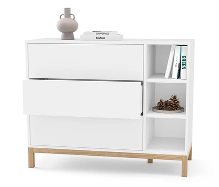 Commode blanche avec trois tiroirs, dont un est ouvert. Un vase et des livres sont posés sur la commode.