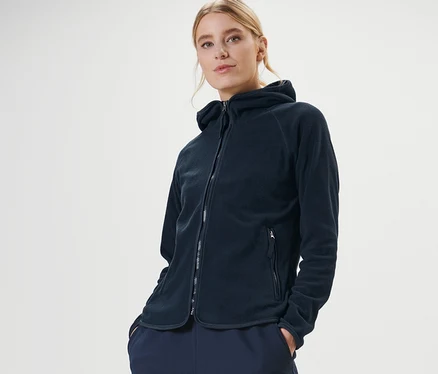 Femme posant dans une veste en polaire à capuche bleu foncé.