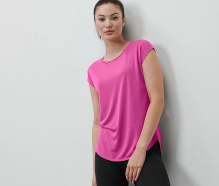 Une femme porte un t-shirt de sport rose vif.