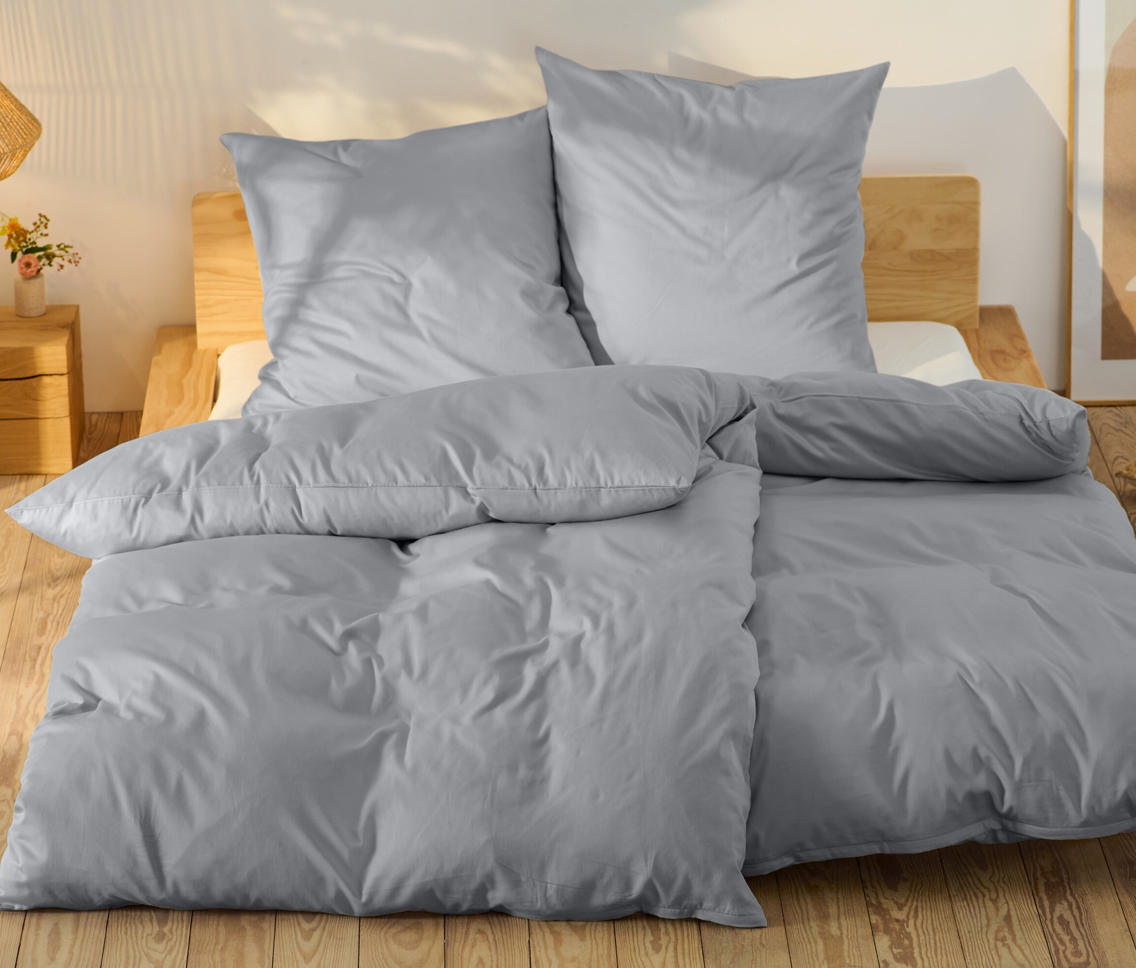 Parure de lit grise en satin de coton, taille normale et grande taille, sur un lit.