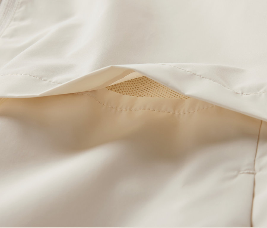 Détail d'une veste de sport coupe-vent crème.