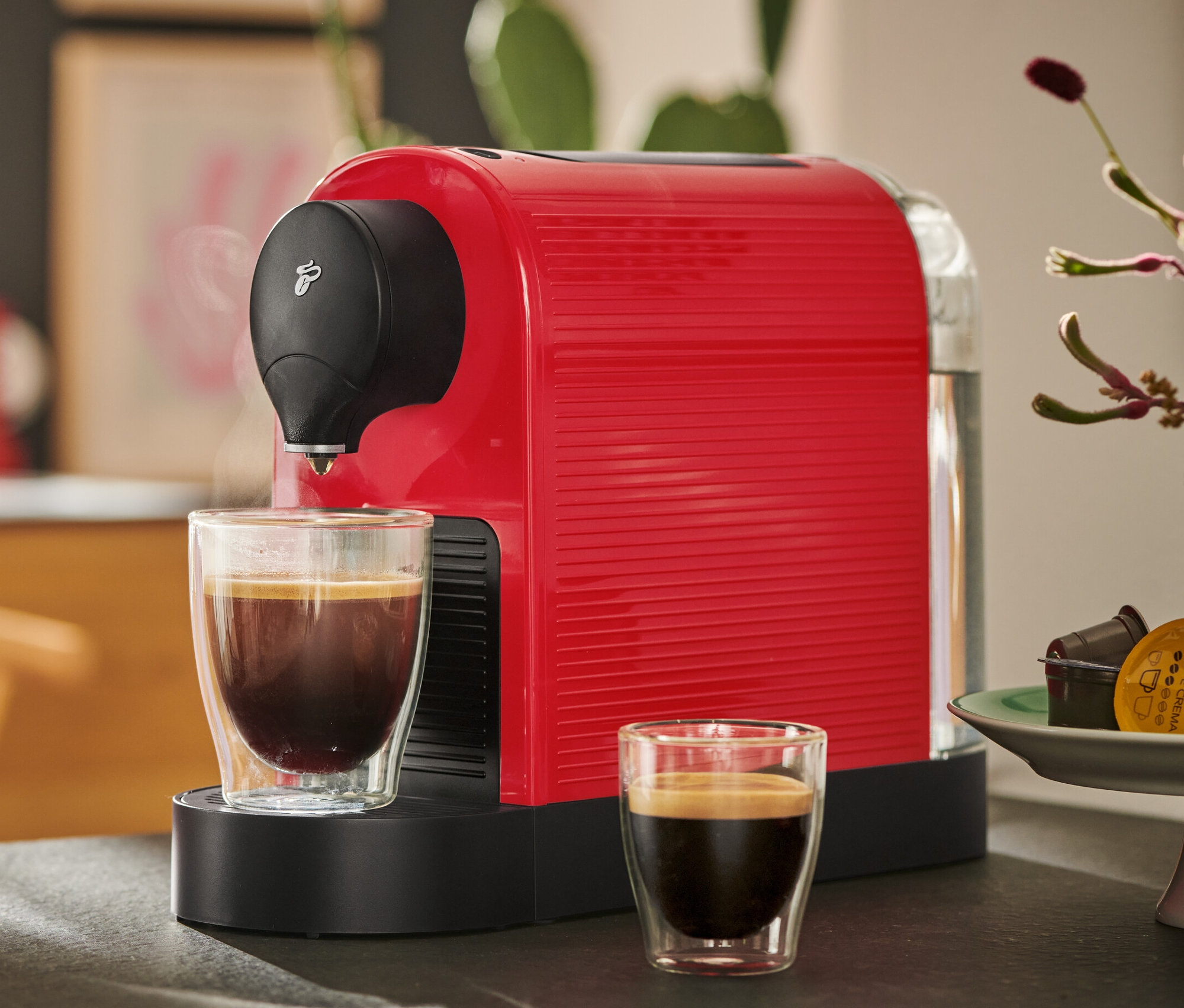 Machine à café rouge Cafissimo pure+ avec deux tasses de café.