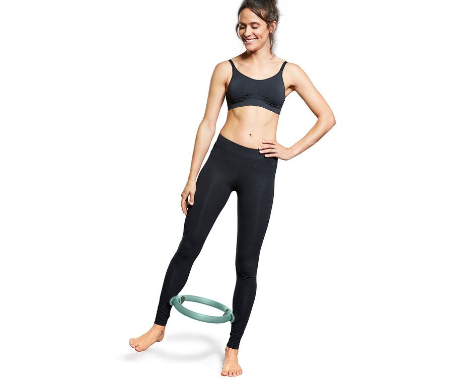 Femme utilisant un anneau de pilates.