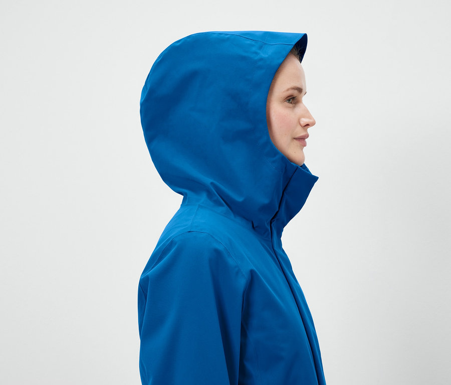Profil d'une femme portant une veste bleue à capuche.