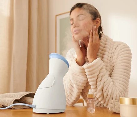 Femme utilisant un sauna facial.