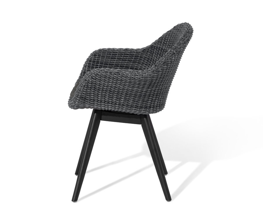 Chaise à coque grise avec tressage en polyrotin et pieds noirs.