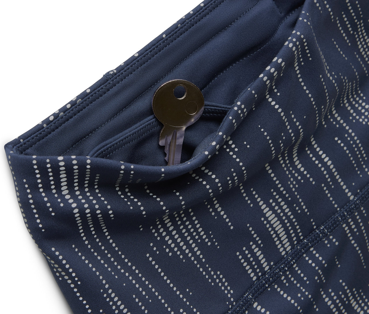 Gros plan de leggings bleu à motifs avec une clé dans la poche.