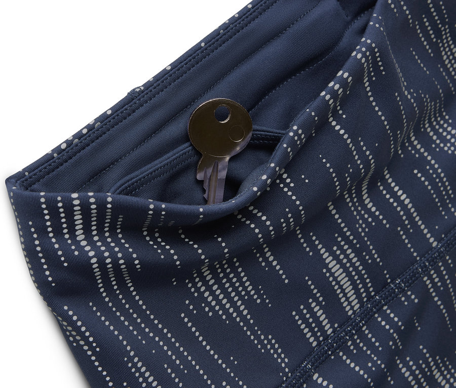 Gros plan de leggings bleu à motifs avec une clé dans la poche.