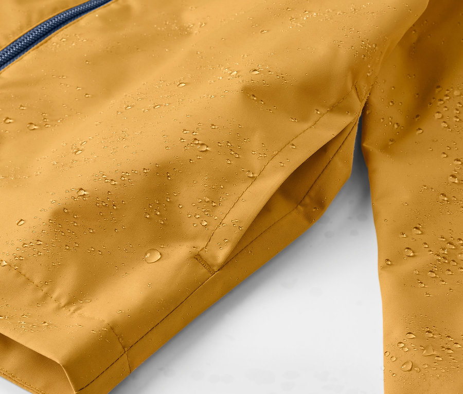 Gros plan sur une veste de pluie jaune pour enfant avec des gouttes d'eau.