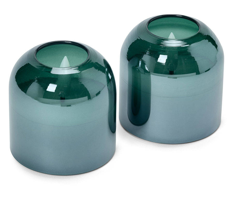 Deux bougies en verre bleu et vert sur un fond blanc.