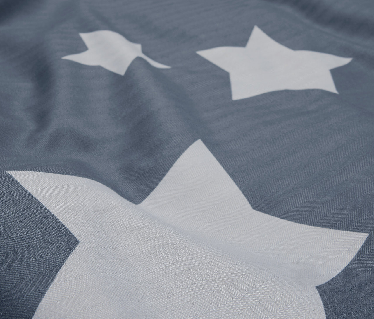 Gros plan d'un tissu gris avec des étoiles blanches.