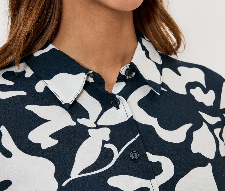 Gros plan sur une chemise pour femme à motif floral bleu marine et blanc.
