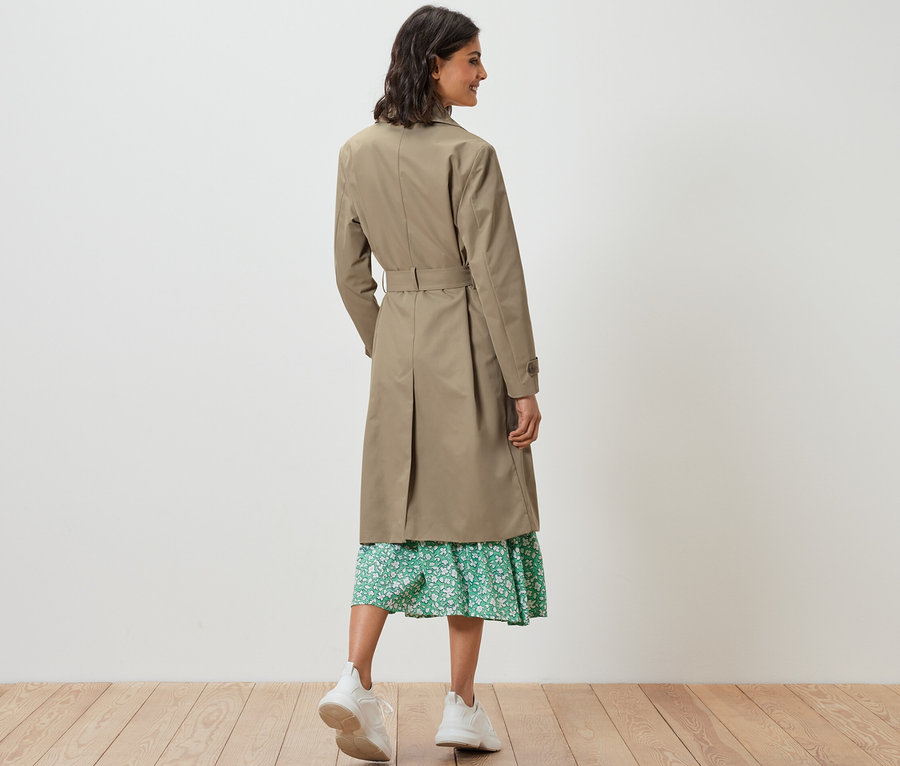 Femme vue de dos portant un trench-coat sable.