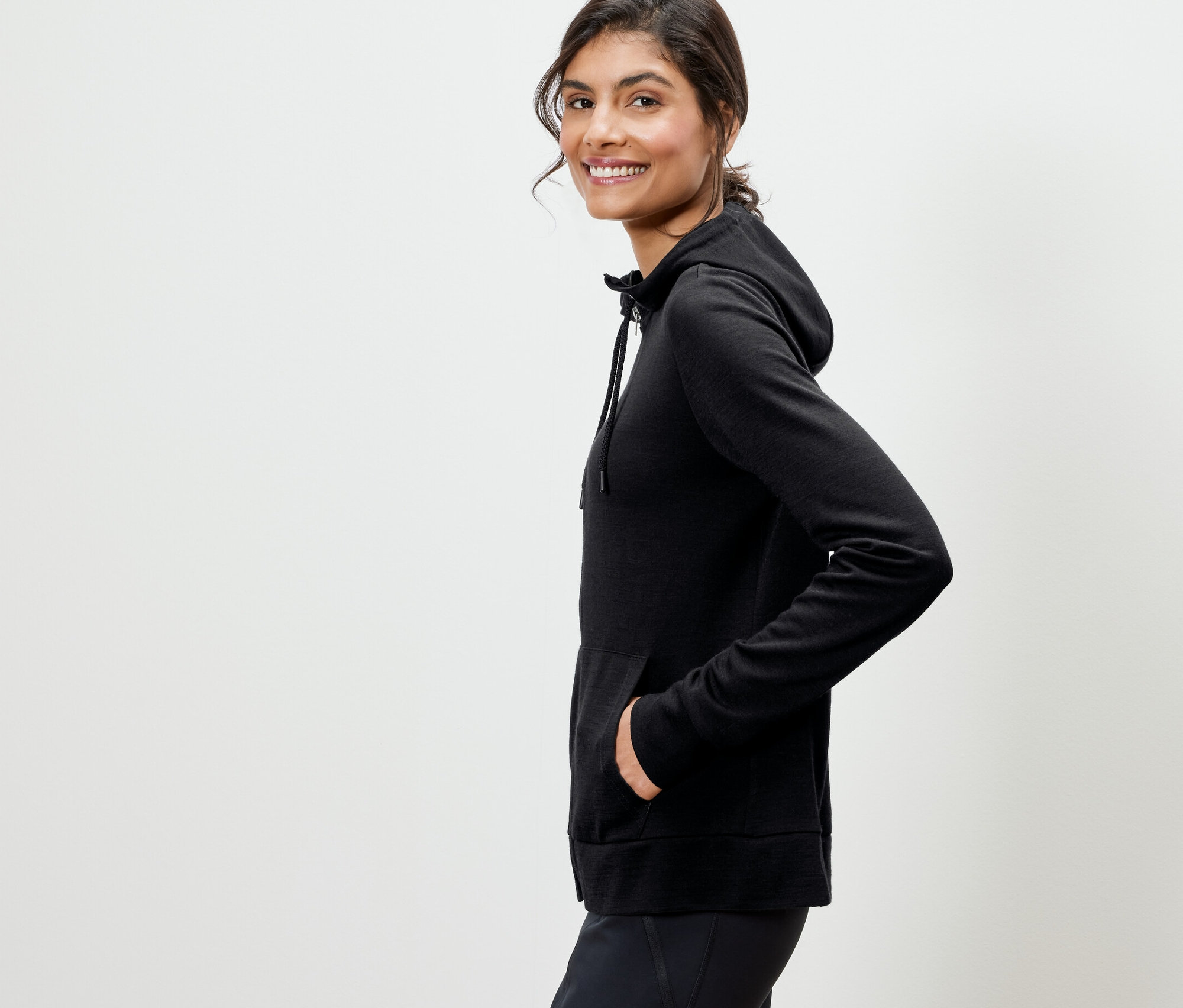 Femme posant dans un veste à capuche noire en laine certifiée RWS.