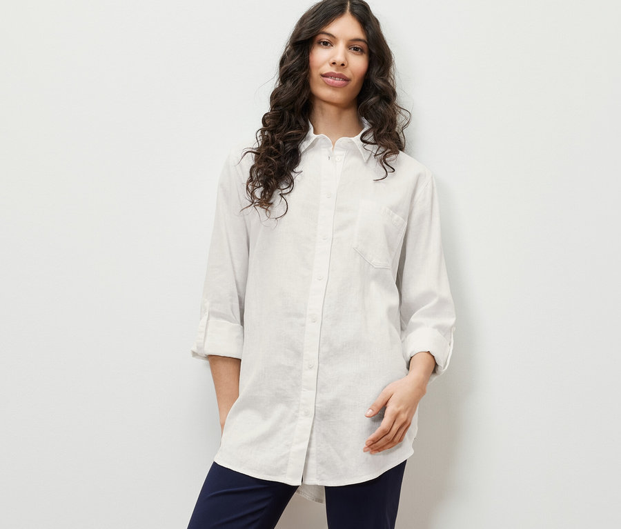Femme posant en blouse longue en lin, blanche.