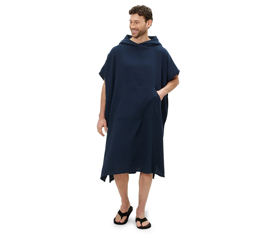 Un homme portant un poncho en mousseline et des tongs.