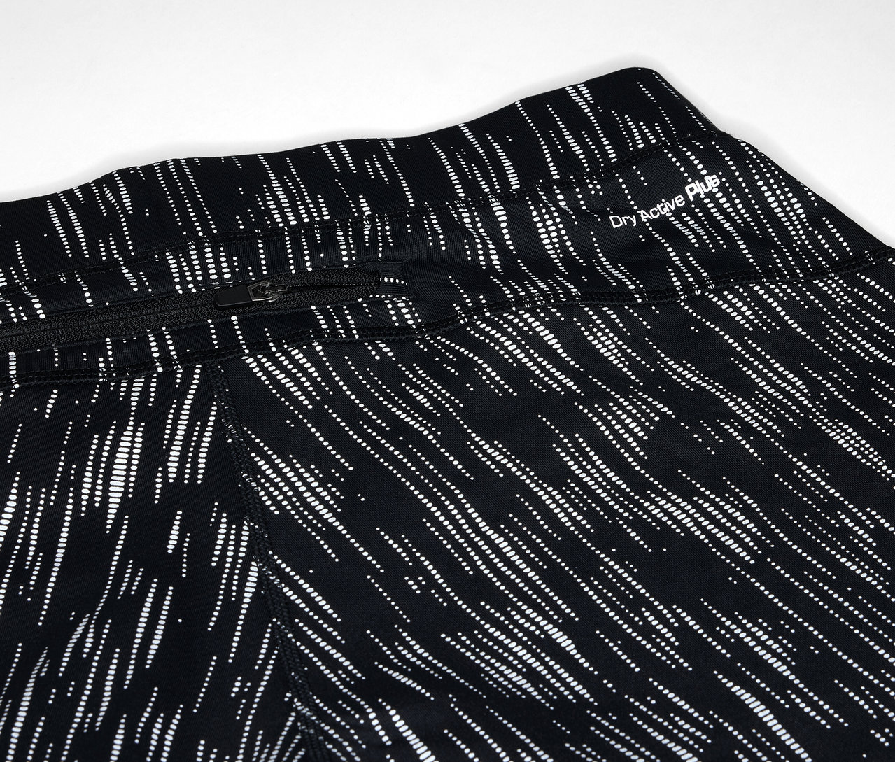 Gros plan sur un legging noir avec un motif de lignes blanches et une poche zippée.