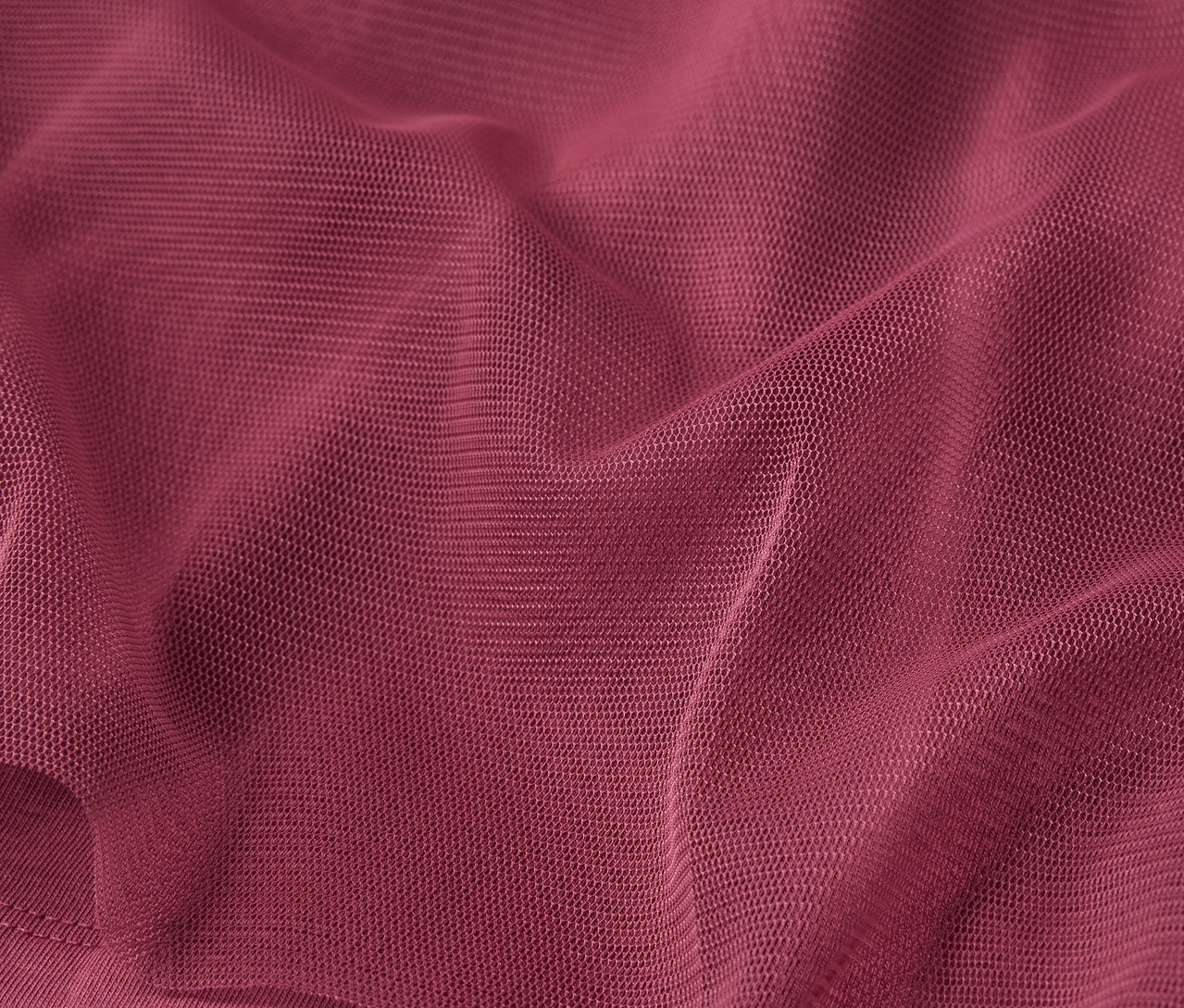 Gros plan sur un tissu bordeaux avec une texture fine et des plis.