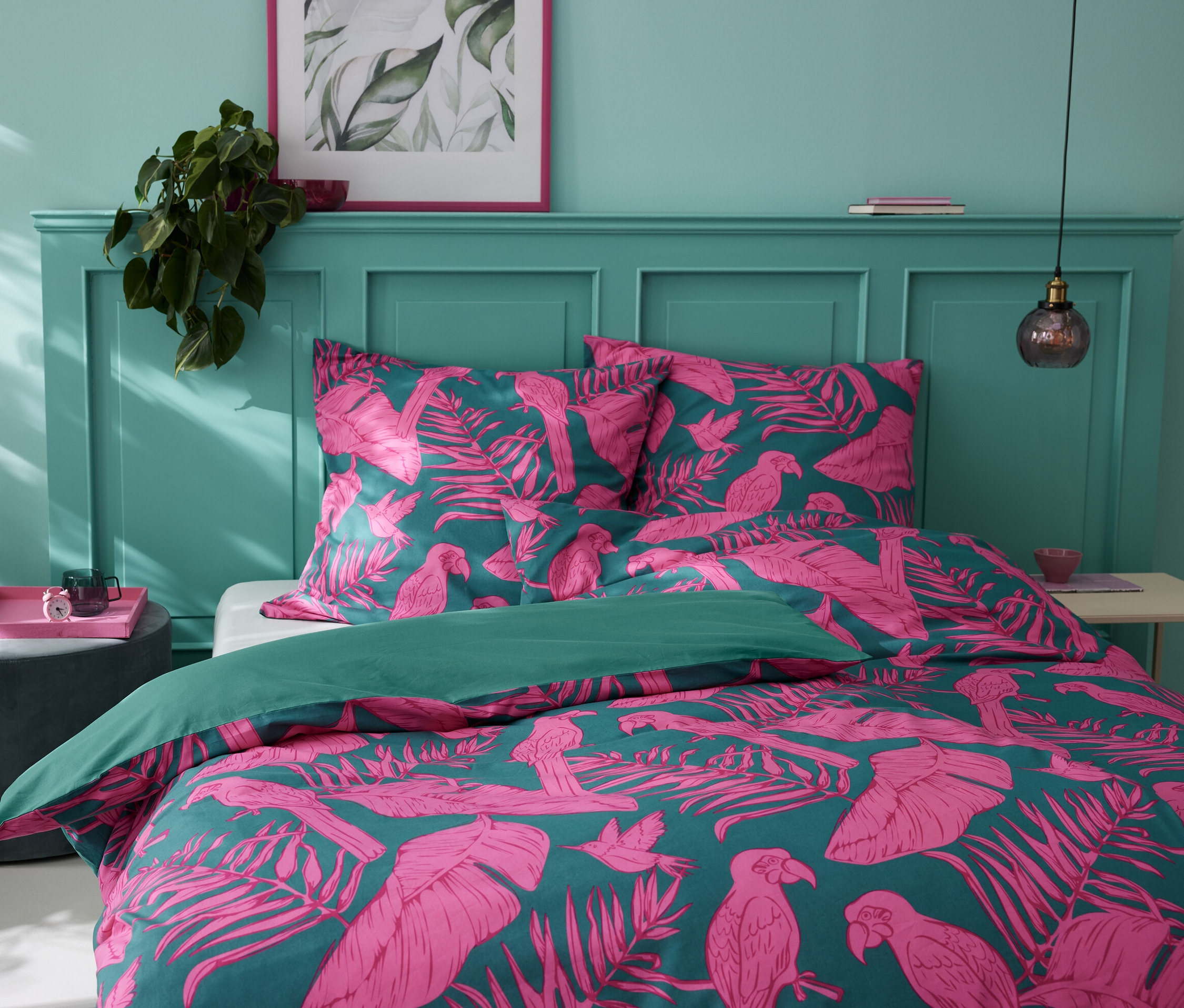 Parure de lit en renforcé, vert tropical, taille normale avec motif tropical de feuilles et de perroquets sur un lit.