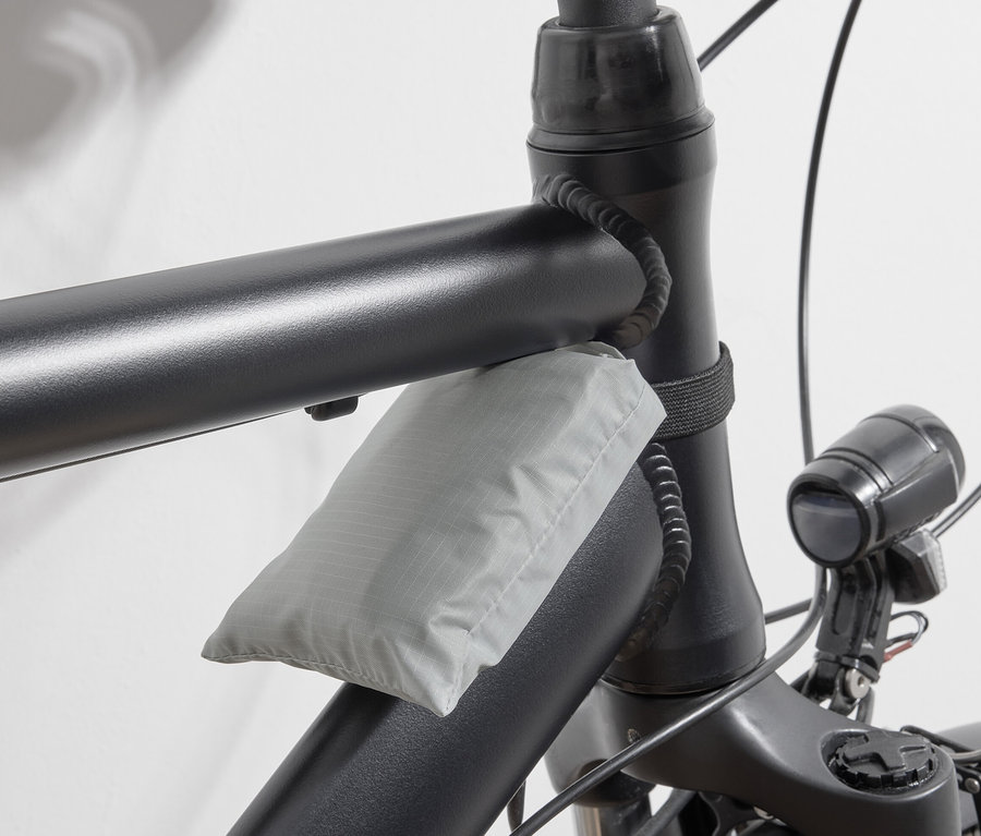 Sac à provisions gris pour vélo fixé au cadre du vélo.