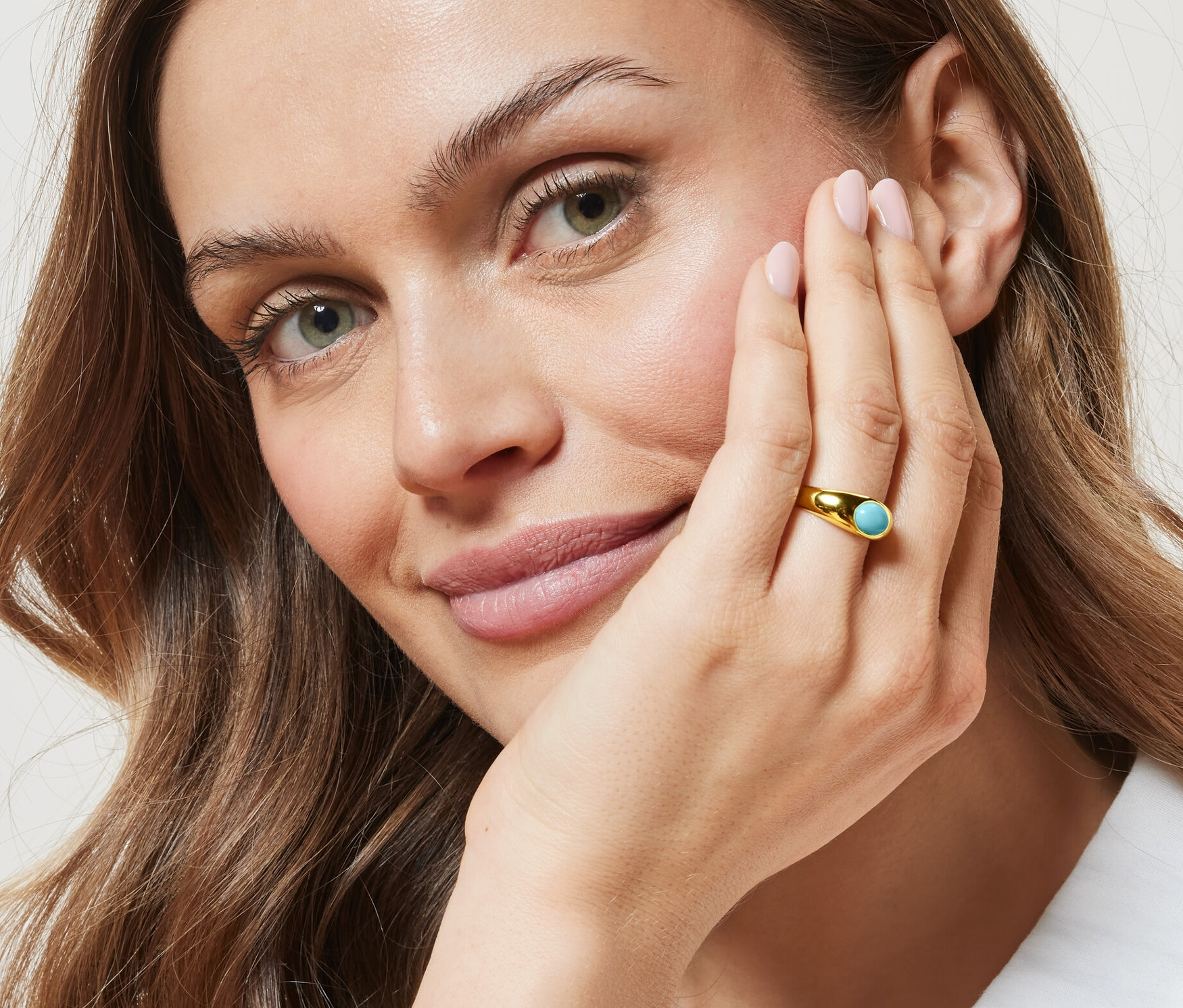 Femme portant une bague avec pierre turquoise.