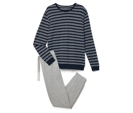 Un haut à manches longues rayé et un pantalon de jogging gris sont posés l'un sur l'autre.