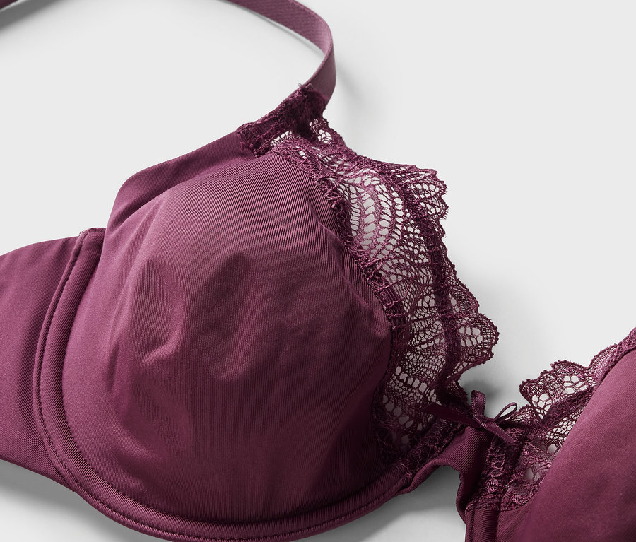 Détail d'un soutien-gorge à armatures bordeaux avec dentelle.