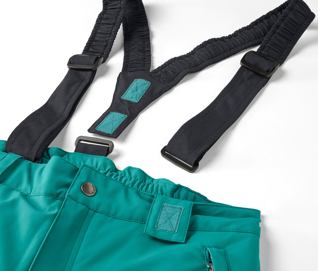 Détail d'un pantalon vert avec des bretelles élastiques noires sur fond blanc.