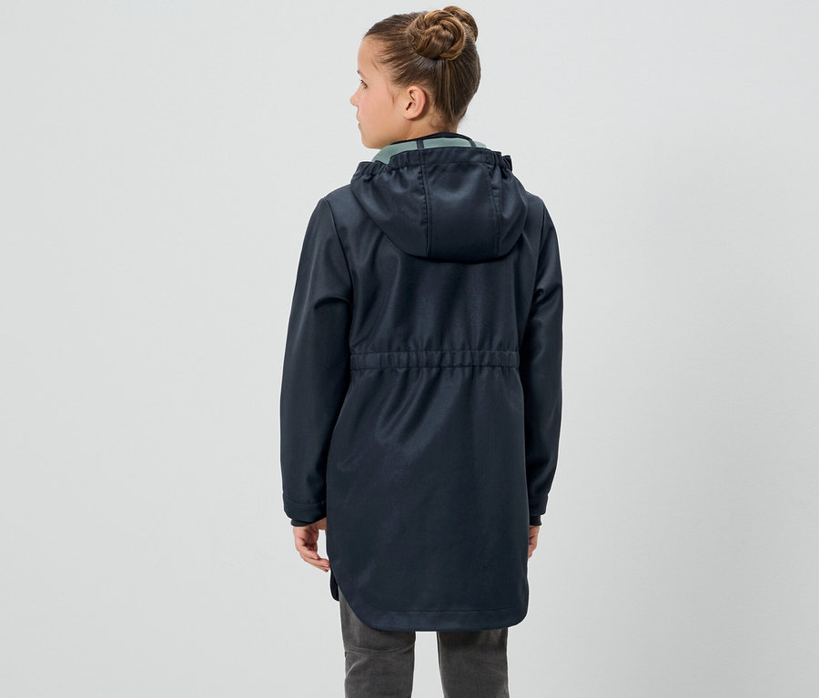 Une fille, vue de dos, porte un manteau softshell pour enfant.