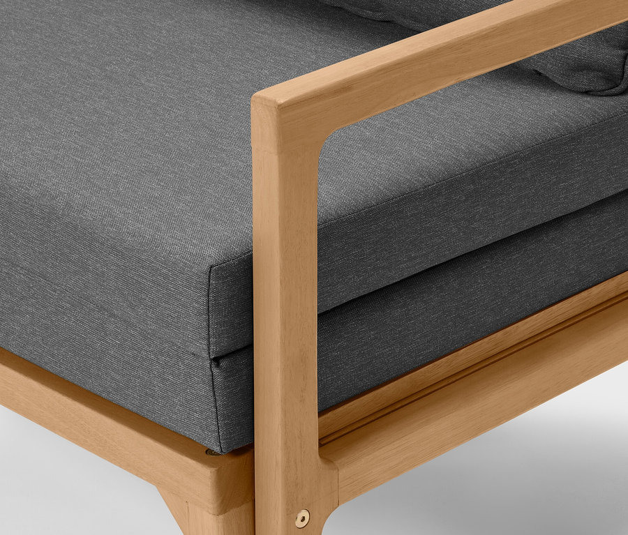 Vue détaillée d'un canapé lounge extensible avec des coussins gris et un cadre en bois clair.
