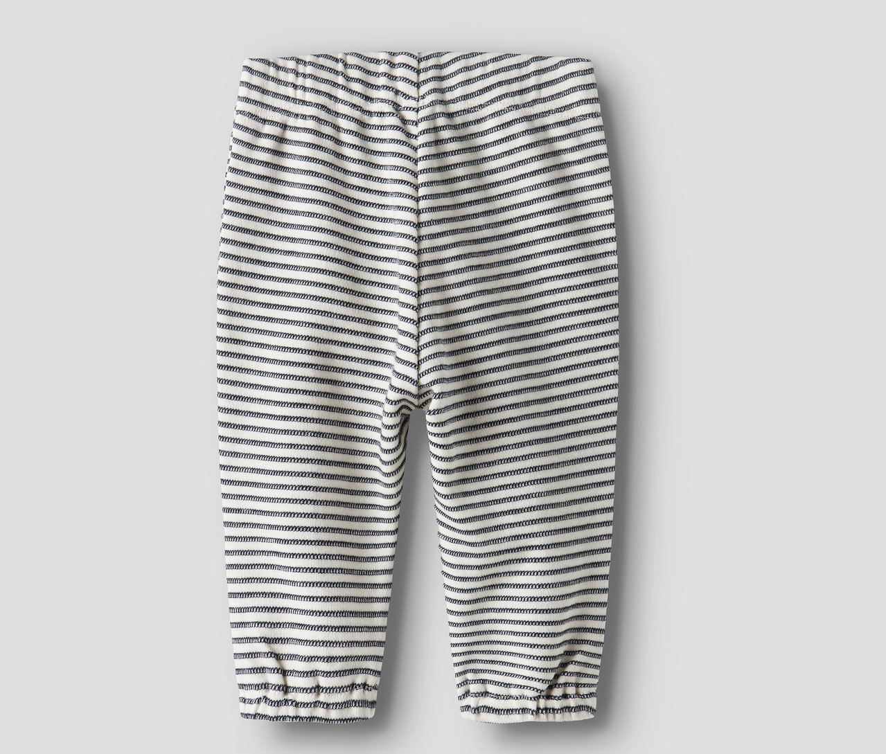 Le dos d'un pantalon de survêtement rayé NAME IT Baby sur fond gris.