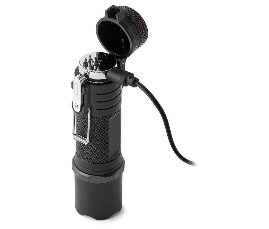 Une lampe de poche noire est en charge avec un câble.