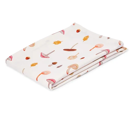 Tissu blanc plié avec des motifs de champignons et de feuilles.