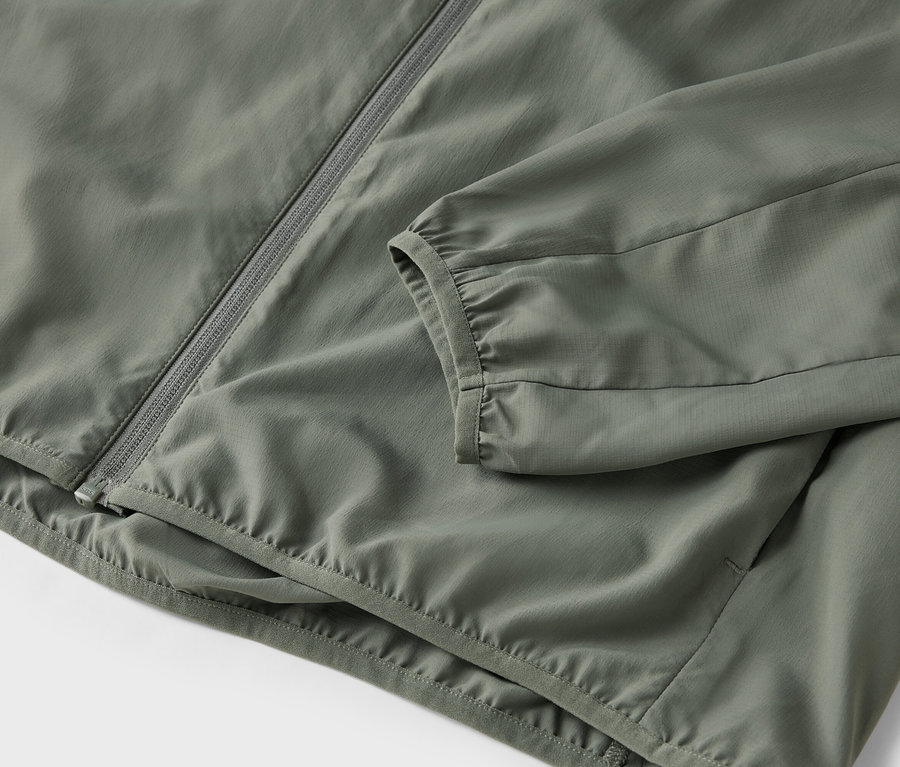 Gros plan d'une veste olive avec une fermeture éclair.