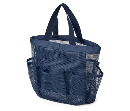 Gros plan d'un sac de douche en maille bleu marine avec de multiples poches extérieures et des poignées de transport, posé sur une surface blanche.