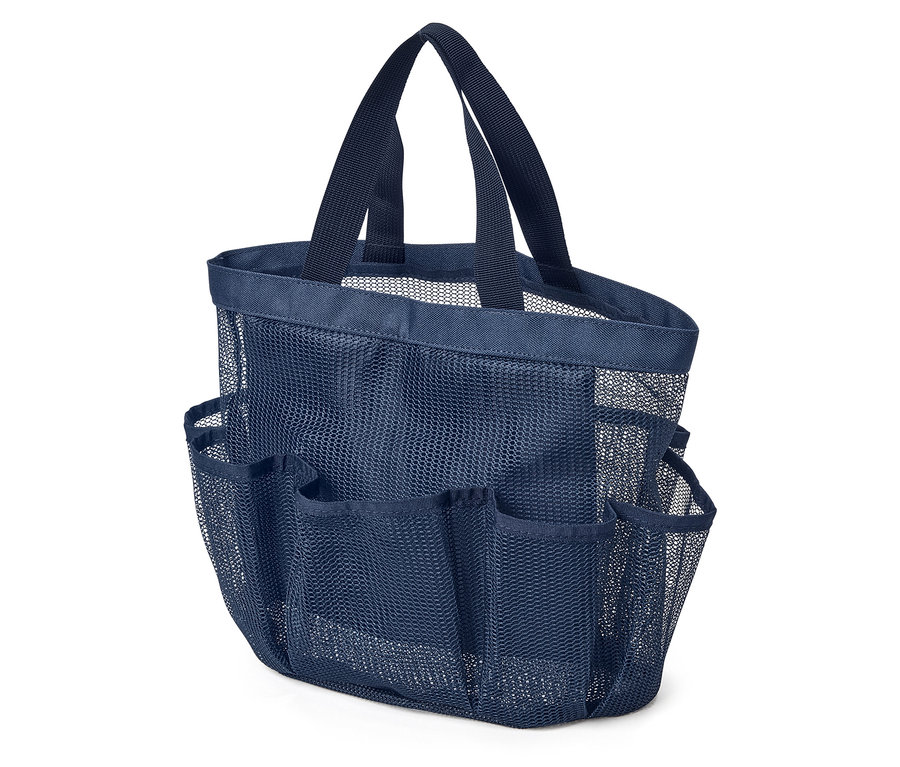 Gros plan d'un sac de douche en maille bleu marine avec de multiples poches extérieures et des poignées de transport, posé sur une surface blanche.