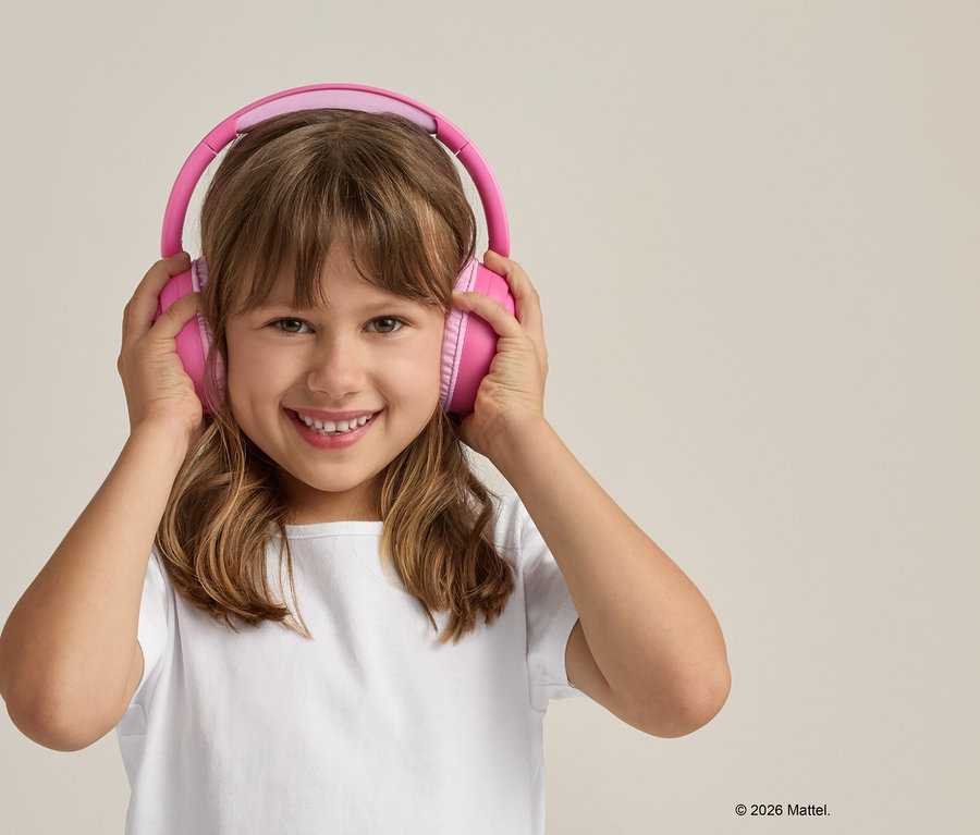 Fillette souriante portant un casque rose et un t-shirt blanc sur un fond beige.