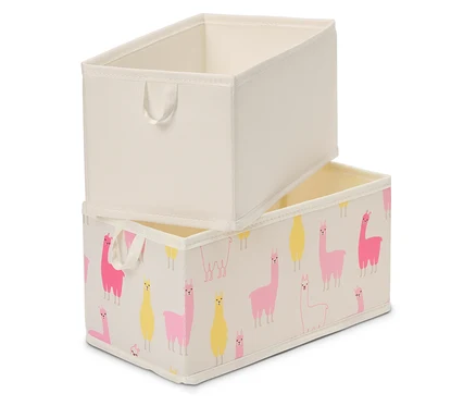Deux boîtes de rangement rectangulaires sont empilées l'une sur l'autre. La boîte supérieure est de couleur beige unie, la boîte inférieure est imprimée de lamas roses et jaunes sur un fond beige.