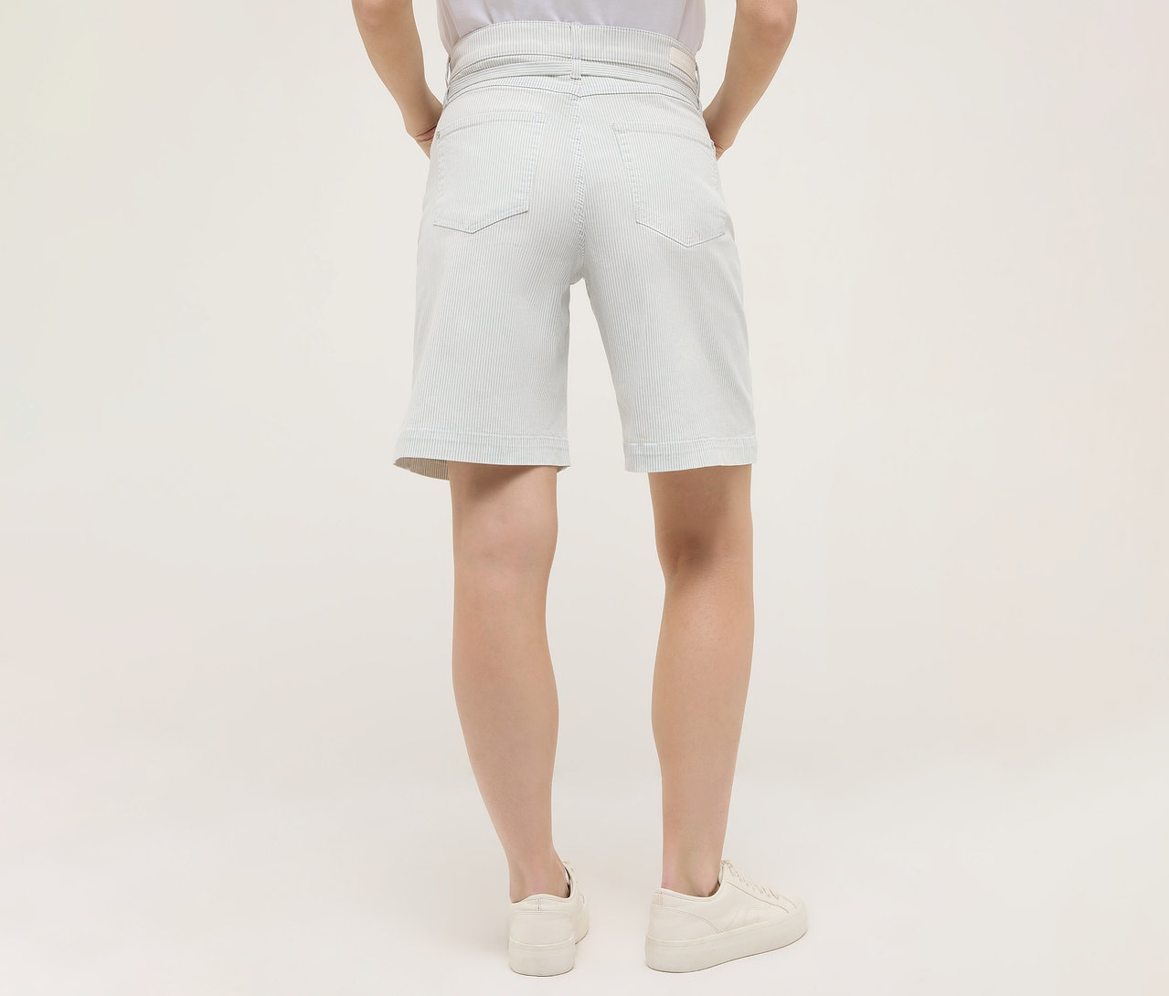 Femme vue de dos portant un short Angels Denim «
Lia City », rayures et des chaussures blanches.