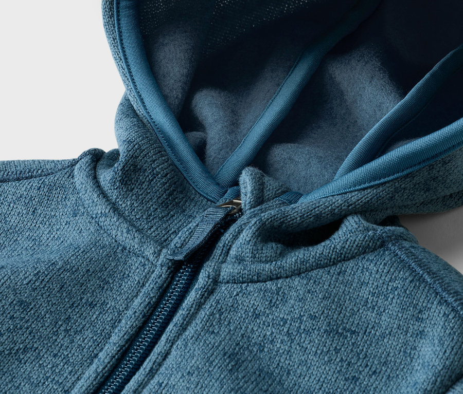 Gros plan d'un sweat à capuche en polaire bleu-vert avec fermeture éclair.